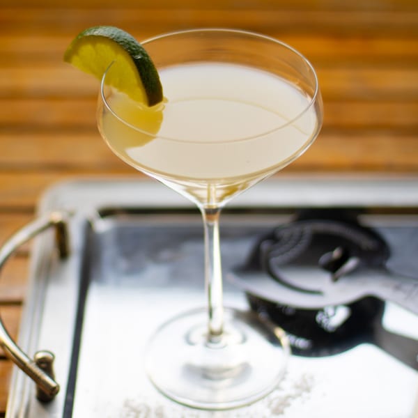 A Picoso's Mexican Kitchen margarita in a coupe glass, garnished with a lime wedge.
