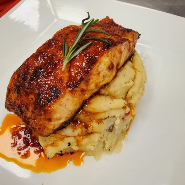 Picoso's Mexican Kitchen's salmon dish, glazed and garnished with rosemary, served over mashed potatoes.